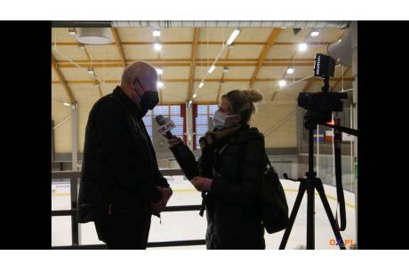 Zdjęcie przedstawia wywiad dwóch osób na tle lodowiska w Cieszynie.
